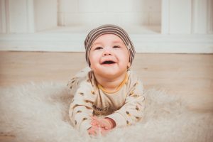 lächelndes Baby liegt auf Kuschelfell